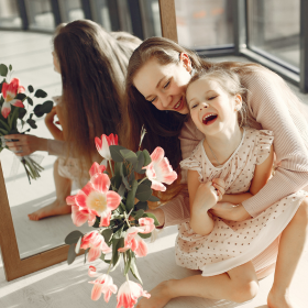 Fille et sa maman avec des fleurs devant un miroir 